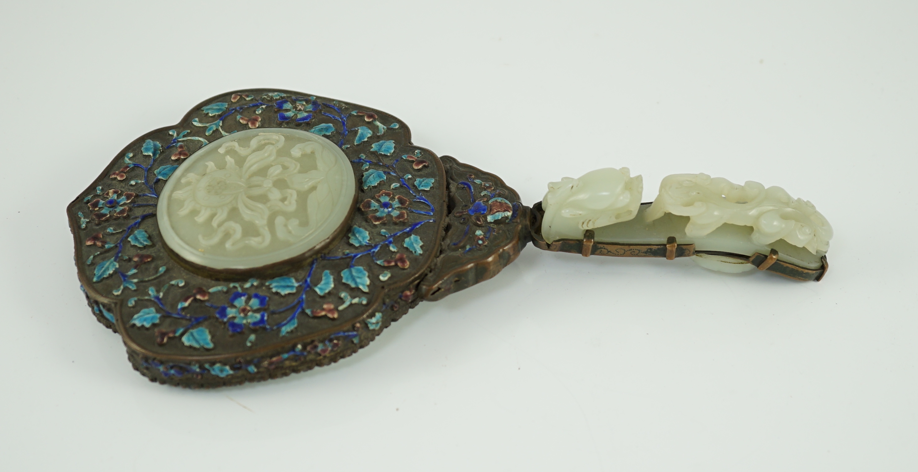 An early 20th century Chinese enamelled copper hand mirror with 18th/19th century Chinese pale celadon jade mounts